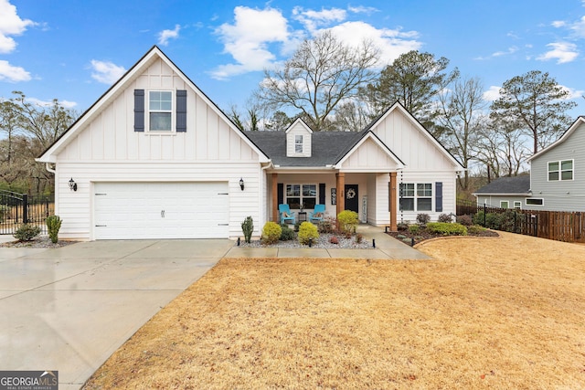 modern farmhouse featuring fence, roof with shingles, board and batten siding, concrete driveway, and a front yard