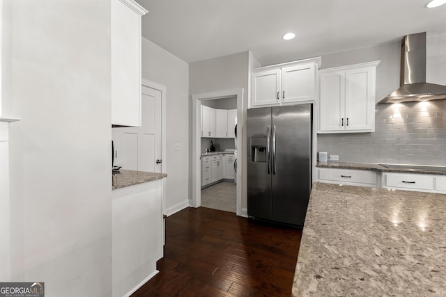 kitchen featuring stainless steel refrigerator with ice dispenser, tasteful backsplash, white cabinetry, wall chimney exhaust hood, and black electric cooktop