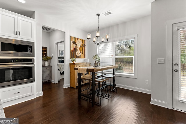 dining area featuring visible vents, baseboards, a notable chandelier, and dark wood-style flooring