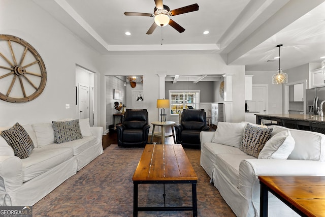 living area featuring recessed lighting, a ceiling fan, a tray ceiling, and ornate columns