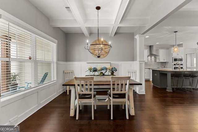 dining area with beam ceiling, dark wood-style floors, coffered ceiling, and a decorative wall