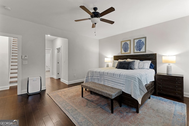 bedroom with dark wood-type flooring, a ceiling fan, and baseboards