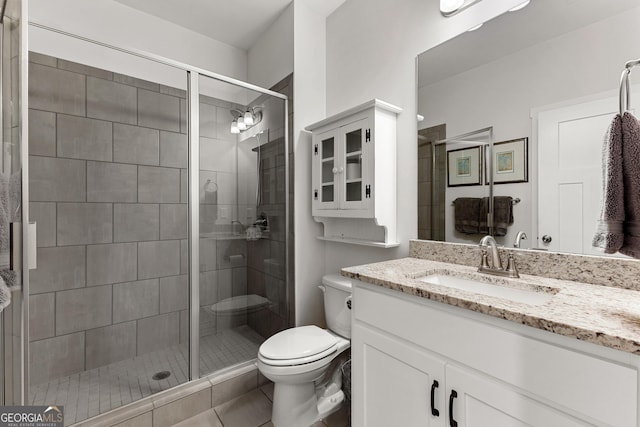 full bath featuring vanity, toilet, and a shower stall