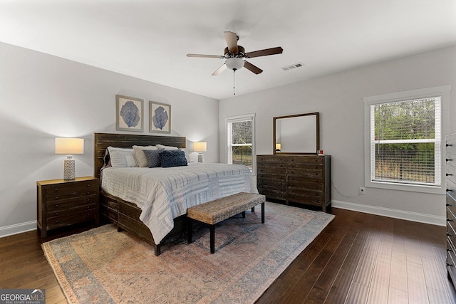 bedroom with ceiling fan, visible vents, baseboards, and dark wood-style floors