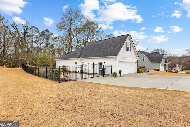 view of home's exterior with fence, concrete driveway, a yard, an attached garage, and a gate