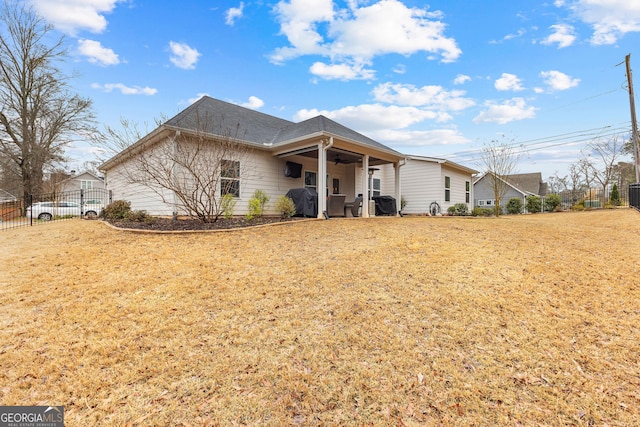 view of front of home featuring a ceiling fan, a front yard, and fence