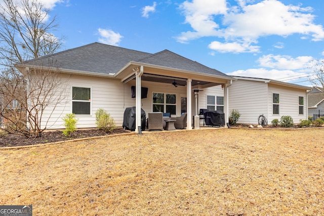 rear view of house featuring a yard, roof with shingles, a ceiling fan, and a patio area