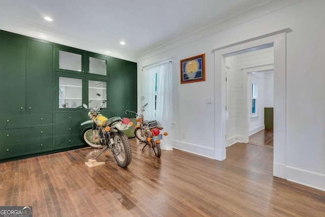 interior space featuring crown molding, baseboards, and wood finished floors