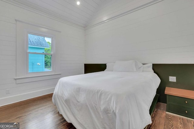 bedroom with baseboards, dark wood-style flooring, and vaulted ceiling