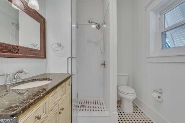 full bathroom featuring vanity, baseboards, a stall shower, tile patterned floors, and toilet