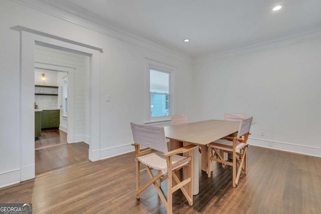 dining room with dark wood-style floors, baseboards, and ornamental molding