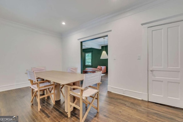 dining area featuring baseboards, wood finished floors, and crown molding