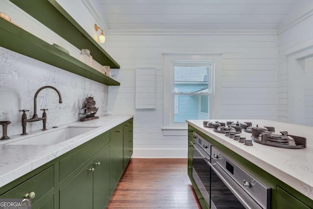 kitchen with a sink, open shelves, green cabinets, and dark wood-style flooring