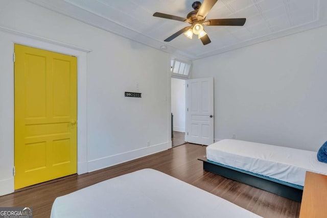 bedroom with ceiling fan, baseboards, and wood finished floors