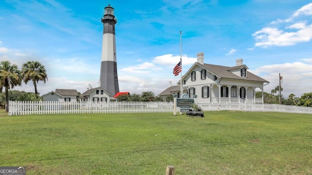 rear view of property featuring a porch, a lawn, and fence