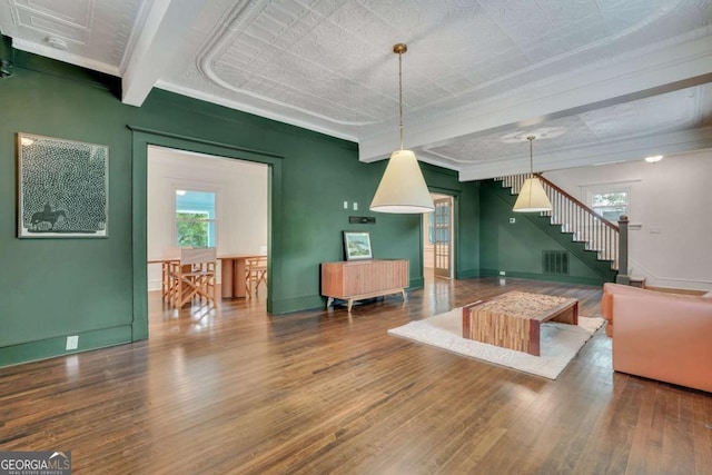 living room featuring stairway, baseboards, and wood finished floors