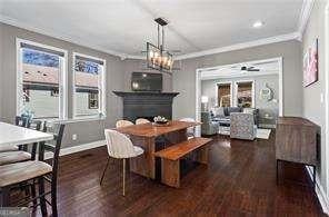 dining space with a notable chandelier, wood finished floors, baseboards, and ornamental molding