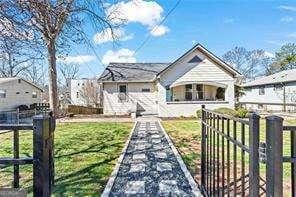 bungalow-style home featuring a front yard and fence