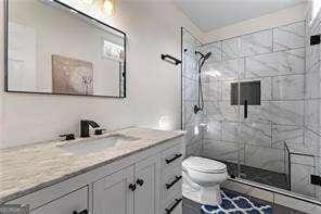 bathroom featuring vanity, toilet, and a stall shower