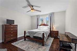 bedroom featuring wood finished floors, baseboards, and ceiling fan