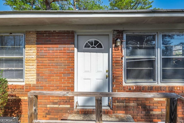 property entrance featuring brick siding