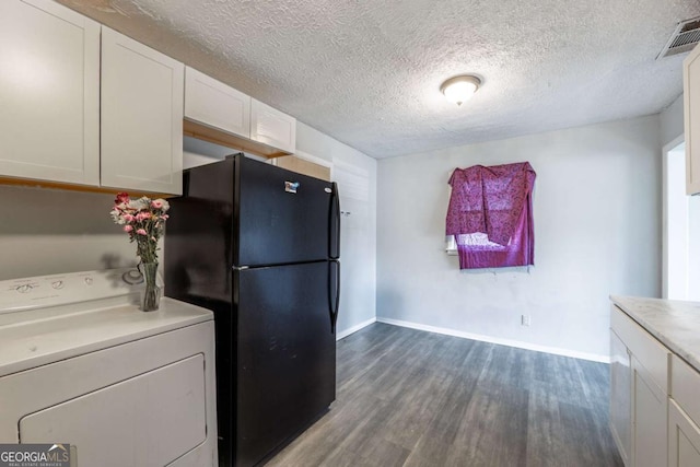 kitchen with visible vents, white cabinetry, freestanding refrigerator, washer / dryer, and dark wood-style flooring