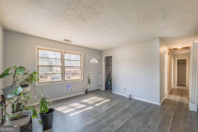 entryway with visible vents, dark wood-style floors, baseboards, and a textured ceiling