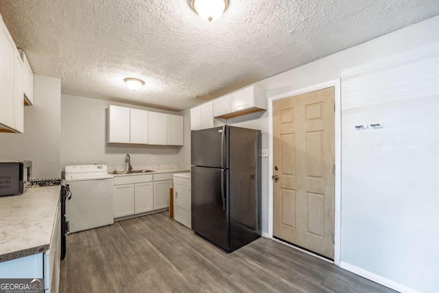 kitchen featuring wood finished floors, white cabinets, black appliances, and a sink