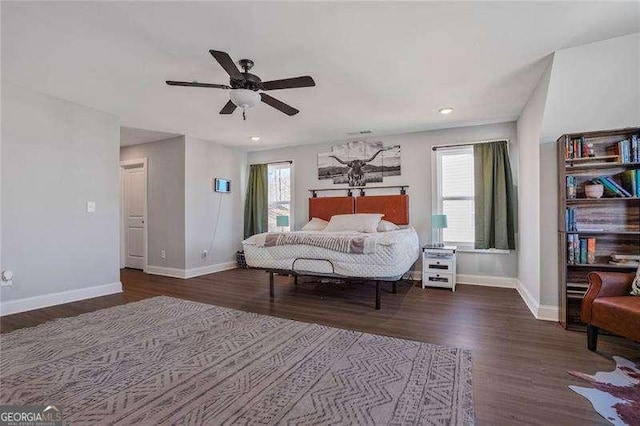 bedroom featuring multiple windows, baseboards, and wood finished floors