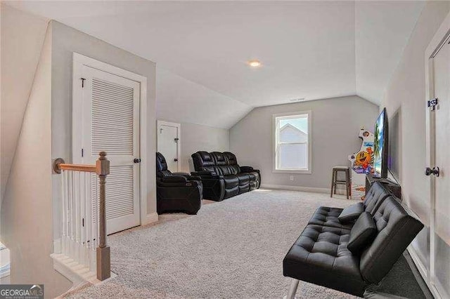 carpeted living area with baseboards and vaulted ceiling