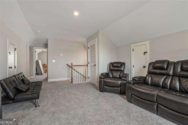 carpeted living room featuring baseboards and lofted ceiling