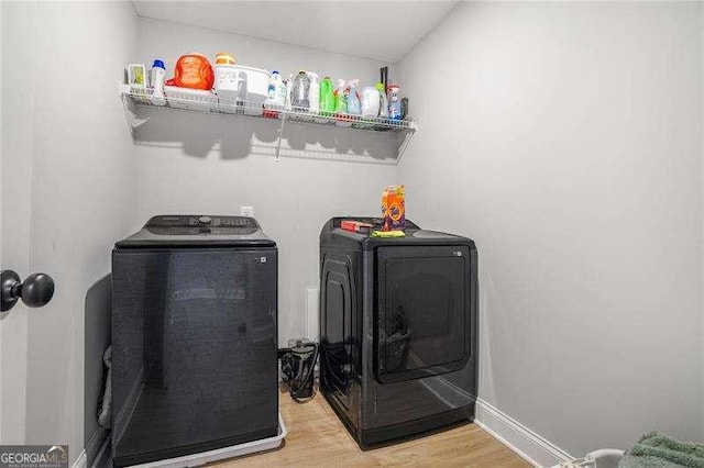 washroom with laundry area, light wood-style flooring, baseboards, and independent washer and dryer