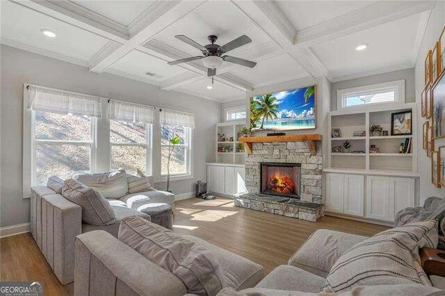 living room with beamed ceiling, coffered ceiling, a fireplace, and wood finished floors