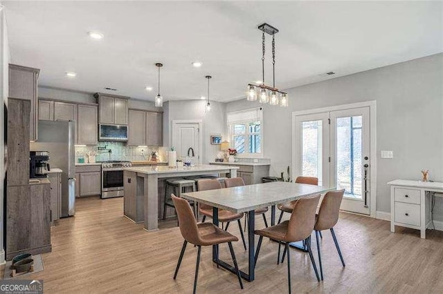 dining room with light wood-style flooring, recessed lighting, and baseboards