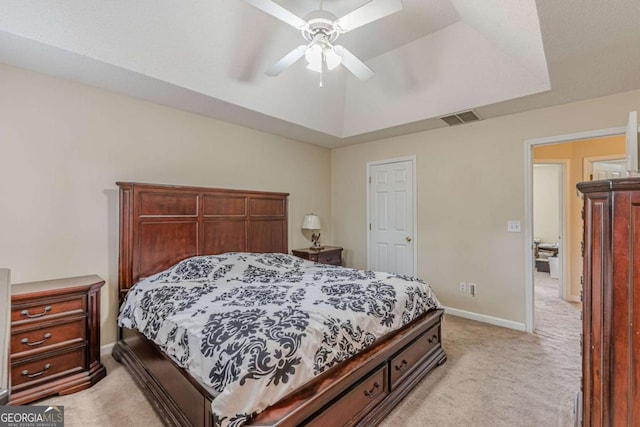 bedroom with a raised ceiling, baseboards, visible vents, and light carpet