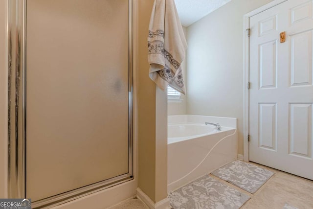 full bath with tile patterned floors, a stall shower, baseboards, and a garden tub