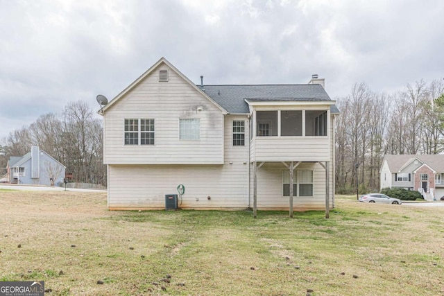 back of house with a lawn, central AC, a chimney, and a sunroom