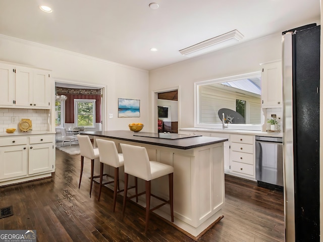 5809 Warren Farm Rd SW, Powder Springs, GA 30127 - kitchen featuring a breakfast bar area, ornamental molding, dark wood finished floors, white cabinetry, and stainless steel appliances