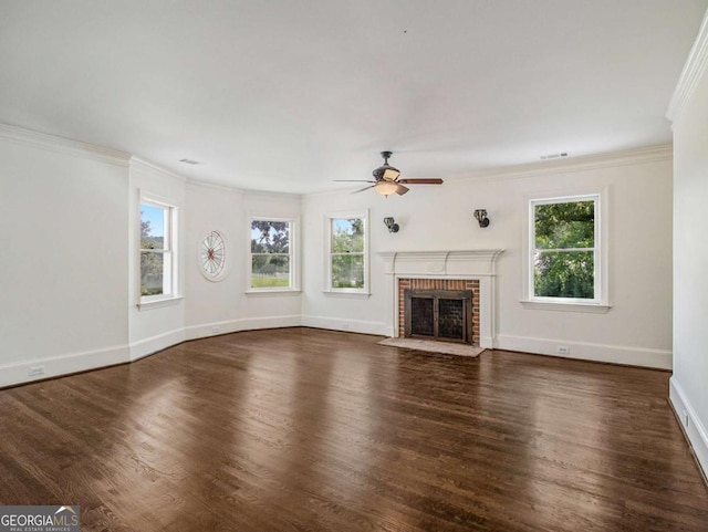 unfurnished living room featuring a brick fireplace, plenty of natural light, and wood finished floors