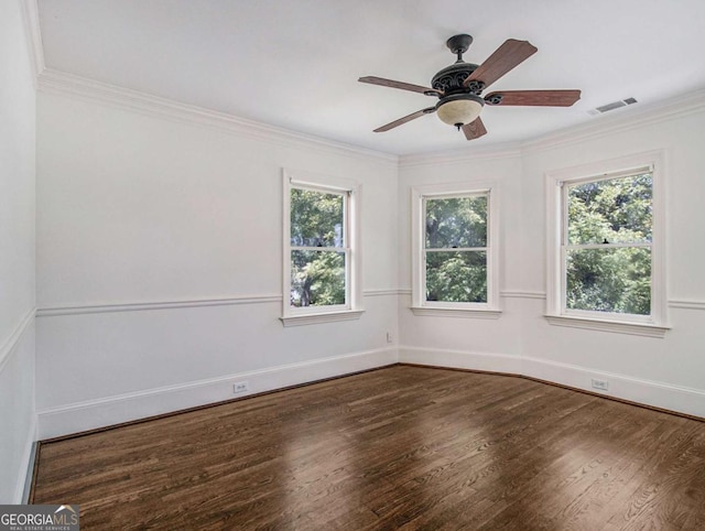 unfurnished room with visible vents, crown molding, baseboards, wood finished floors, and a ceiling fan