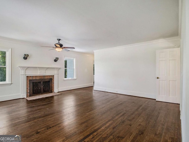 unfurnished living room featuring plenty of natural light, a fireplace, crown molding, and dark wood-style flooring