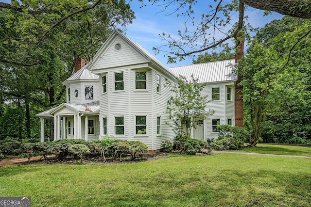 5809 Warren Farm Rd SW, Powder Springs, GA 30127 - victorian house featuring a chimney, a front yard, a standing seam roof, and metal roof