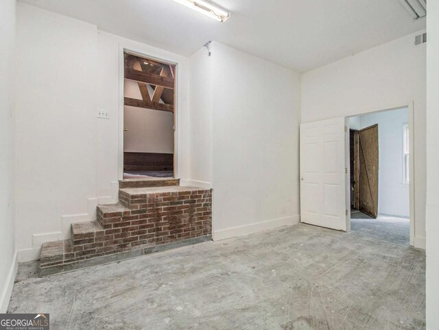 unfurnished living room with visible vents and concrete floors