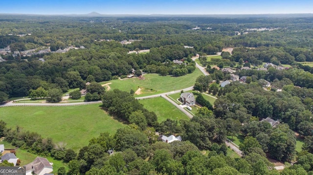 drone / aerial view with a wooded view