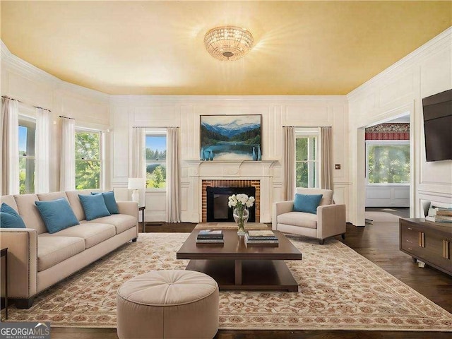 living area with dark wood-style floors, a decorative wall, and a fireplace