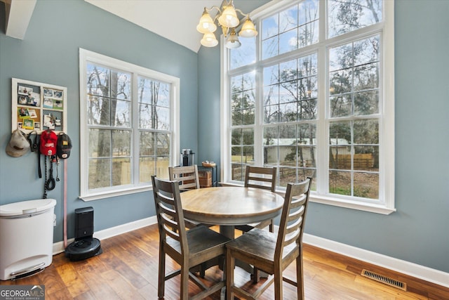 dining space featuring a wealth of natural light, visible vents, and wood finished floors