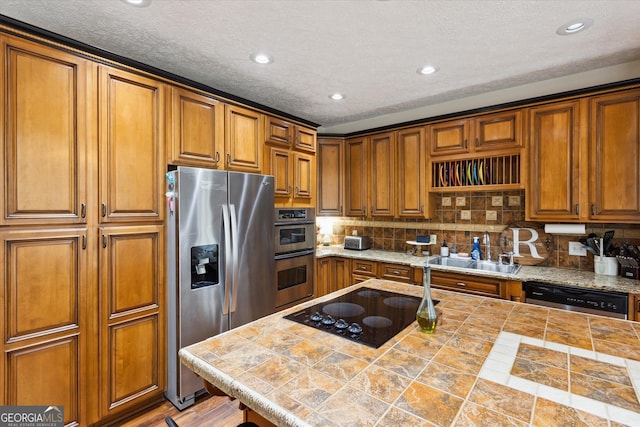 kitchen featuring a sink, appliances with stainless steel finishes, and brown cabinetry