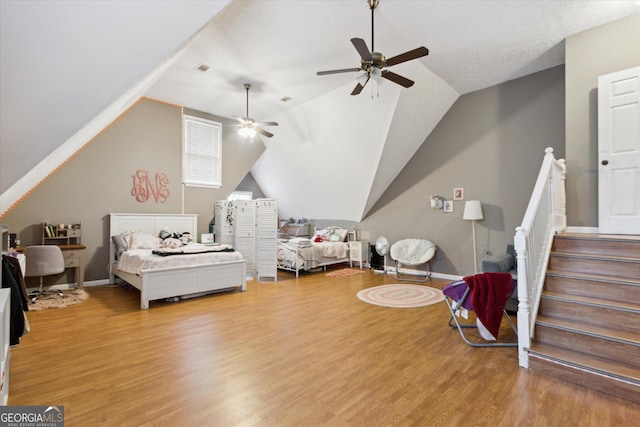 bedroom with baseboards, lofted ceiling, and wood finished floors