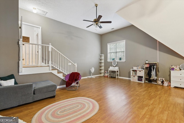 interior space with stairs, wood finished floors, baseboards, and a ceiling fan