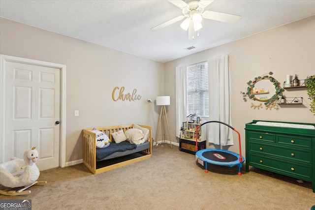 interior space featuring baseboards, carpet flooring, a ceiling fan, and visible vents